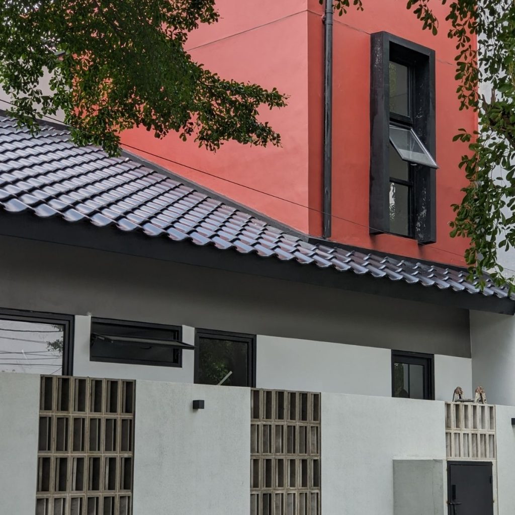 Proyek Adhara House di Tangerang Selatan karya YPA Architecture Studio dan Barakaja Construction menampilkan fasad modern dengan aksen merah, dinding roster beton, dan inner courtyard minimalis dengan kolam air yang terintegrasi dengan interior rumah yang luas.