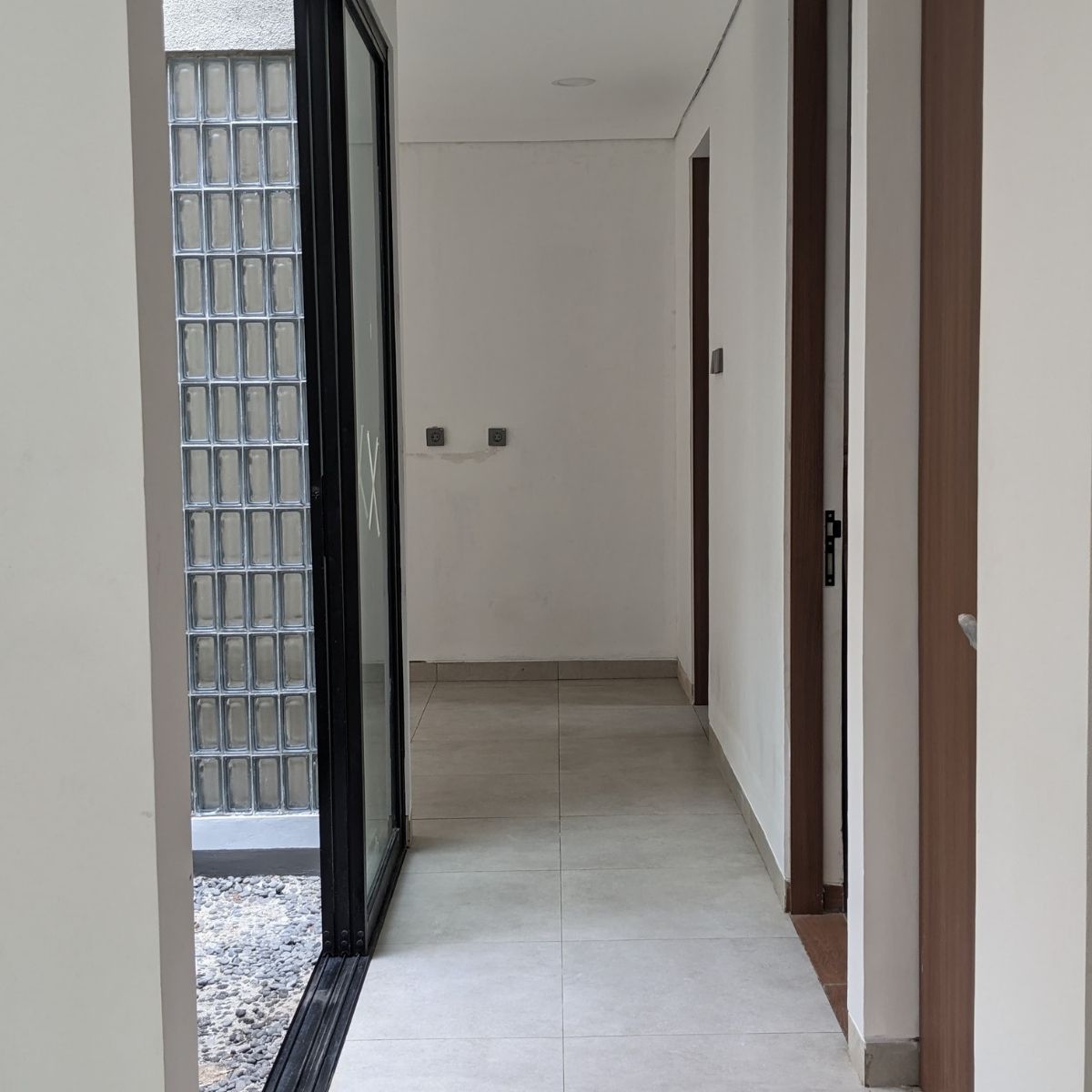 Proyek Adhara House di Tangerang Selatan karya YPA Architecture Studio dan Barakaja Construction menampilkan fasad modern dengan aksen merah, dinding roster beton, dan inner courtyard minimalis dengan kolam air yang terintegrasi dengan interior rumah yang luas.