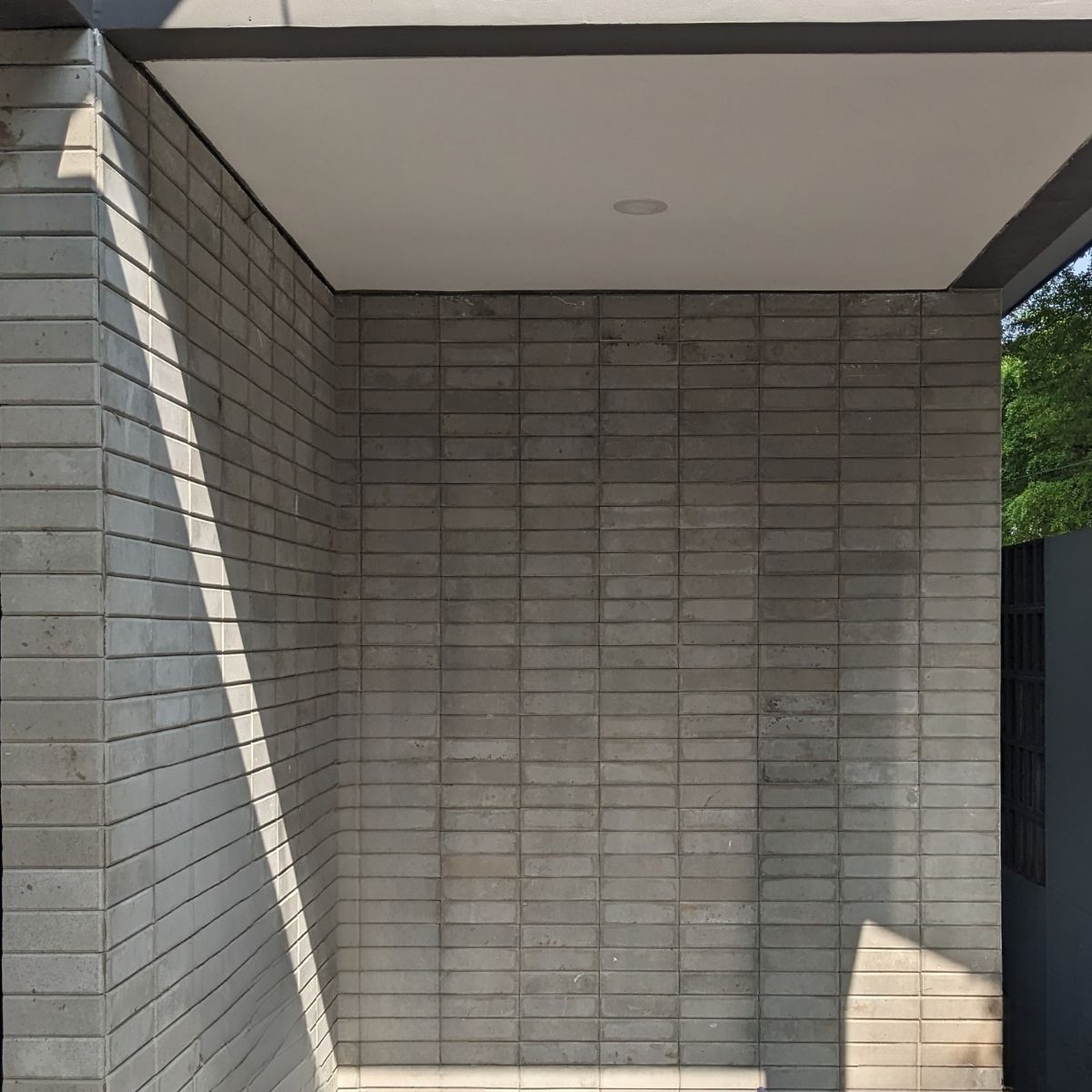 Proyek Adhara House di Tangerang Selatan karya YPA Architecture Studio dan Barakaja Construction menampilkan fasad modern dengan aksen merah, dinding roster beton, dan inner courtyard minimalis dengan kolam air yang terintegrasi dengan interior rumah yang luas.