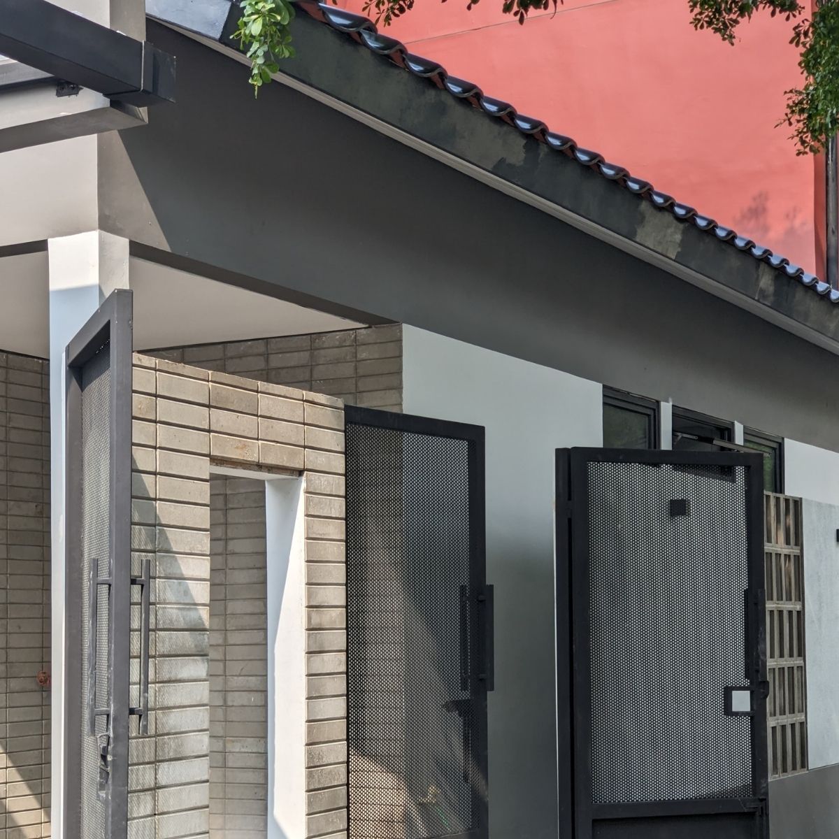 Proyek Adhara House di Tangerang Selatan karya YPA Architecture Studio dan Barakaja Construction menampilkan fasad modern dengan aksen merah, dinding roster beton, dan inner courtyard minimalis dengan kolam air yang terintegrasi dengan interior rumah yang luas.