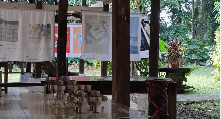 Maket interaktif dan poster program Kampung Gotong Royong Menteng Tenggulun kolaborasi IAI Jakarta x KemenPKP oleh YPA Architecture Studio di Bintaro Design District BDD 2026 Tanah Tinggal, menampilkan desain teknis Rumah Bapak Muslim oleh Ar. Yudha Prasetyo dan Rumah Ibu Mutiah oleh Ar. Titik Efianti & Ricky Geri Ariestivo.